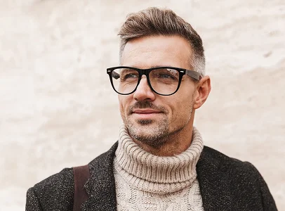 Homme souriant avec cheveux gris, lunettes, pull à col roulé et veste à Montrouge dans les Hauts-de-Seine 92