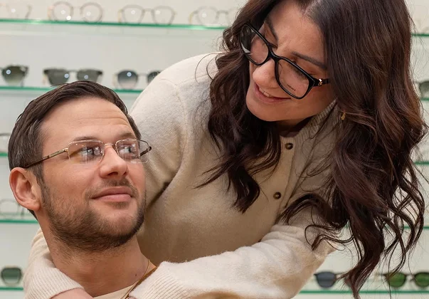 Couple souriant essayant des lunettes dans un magasin d'optique à Montrouge dans les Hauts-de-Seine 92
