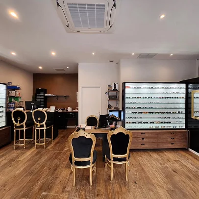 Intérieur d'un magasin d'optique avec présentoirs de lunettes et chaises élégantes.